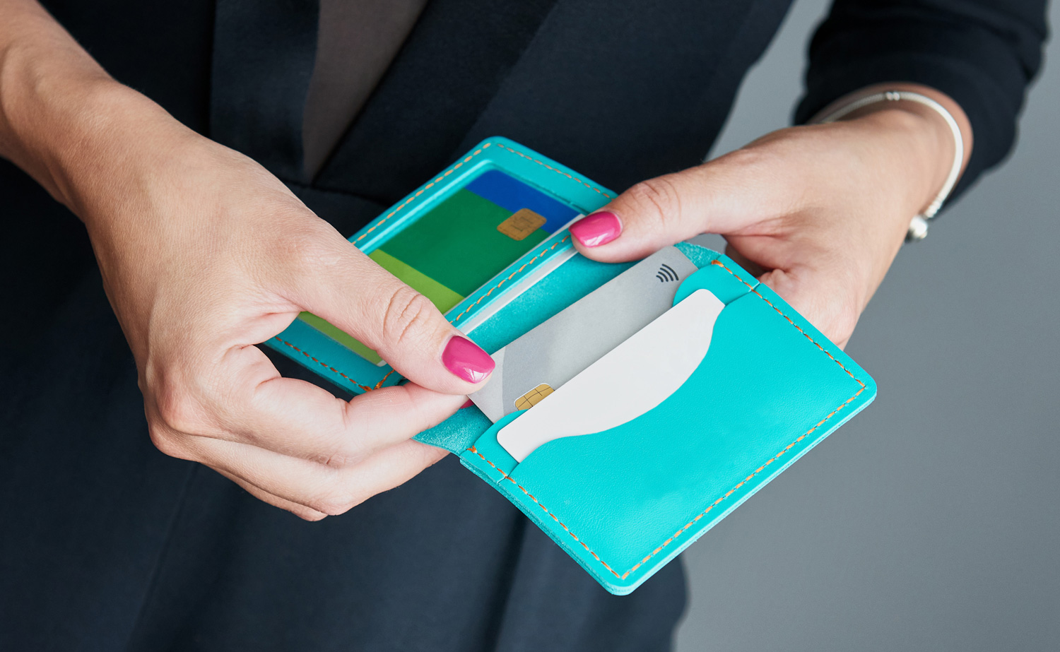Una ejecutiva bancaria extrae su tarjeta de crédito de su cartera mientras se prepara para realizar una transacción financiera.